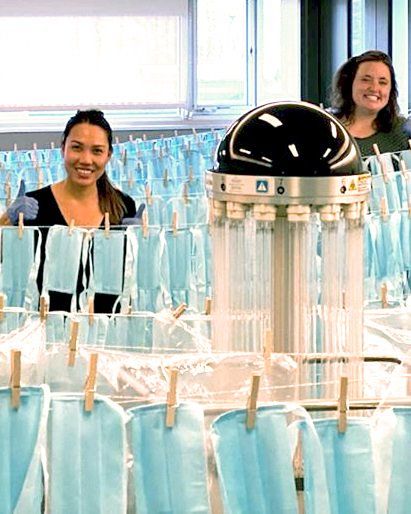 PS&D Recruiter Caitlin Olive, a white woman, smiling surrounded by freshly sterilized masks hanging from a clothes pins.