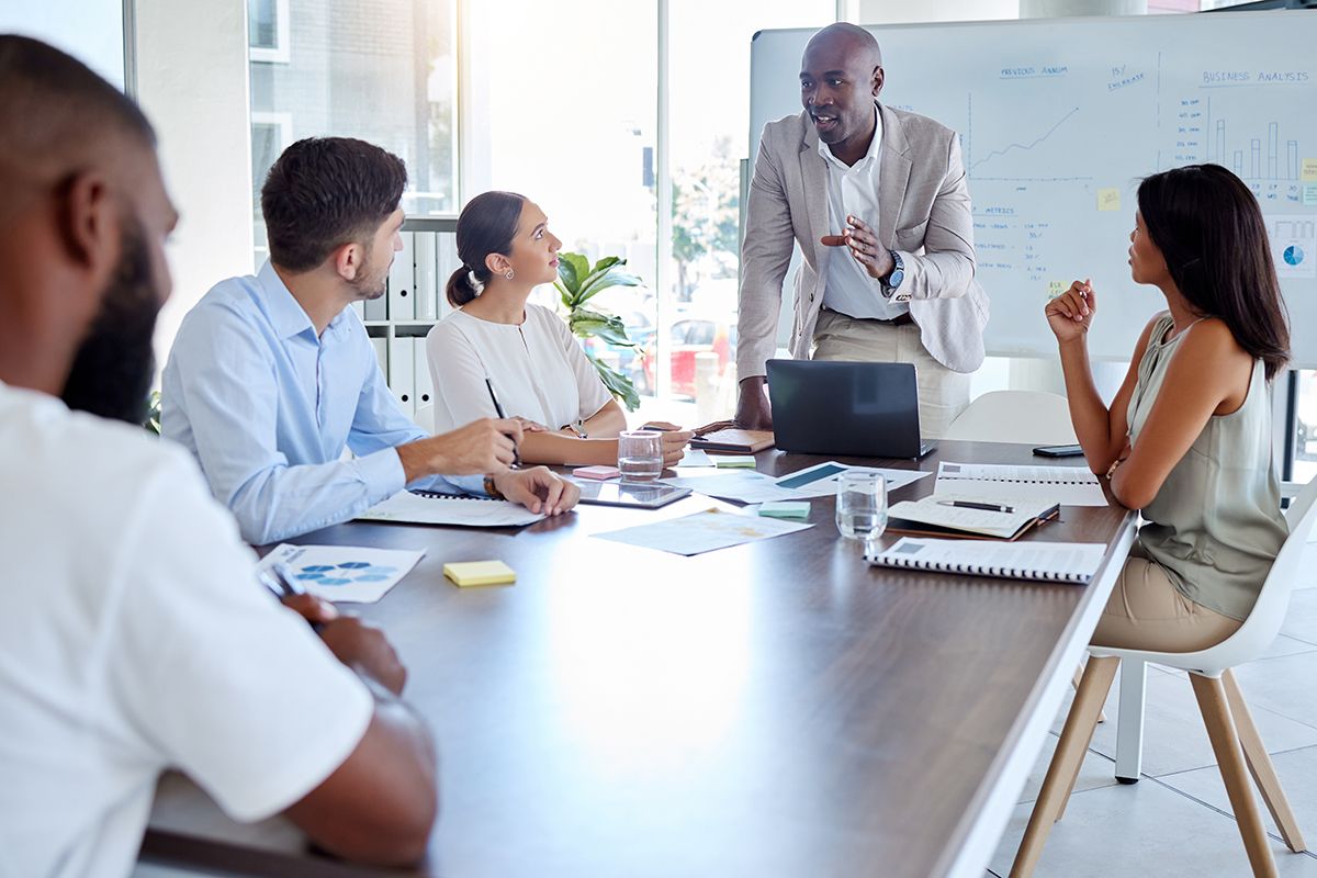 A multicultural group of business professionals at a table in a meeting.