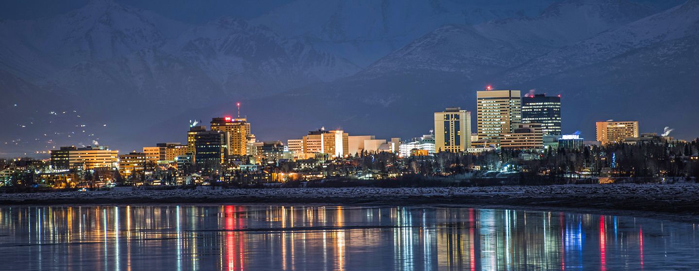 A river with a downtown view at night in Anchorage, Alaska.