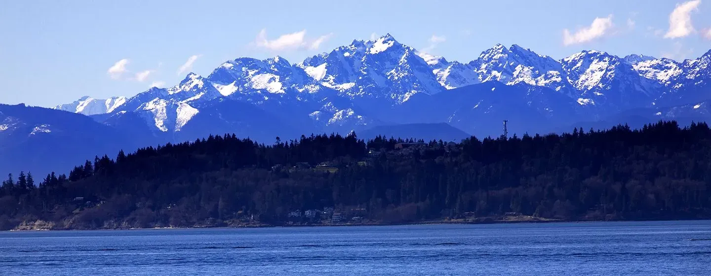 Snowy mountains by a river in Everett, Washington.