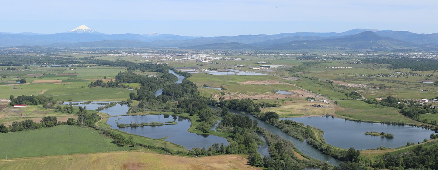 Aerial view of Medford, Oregon grassy fields and river.
