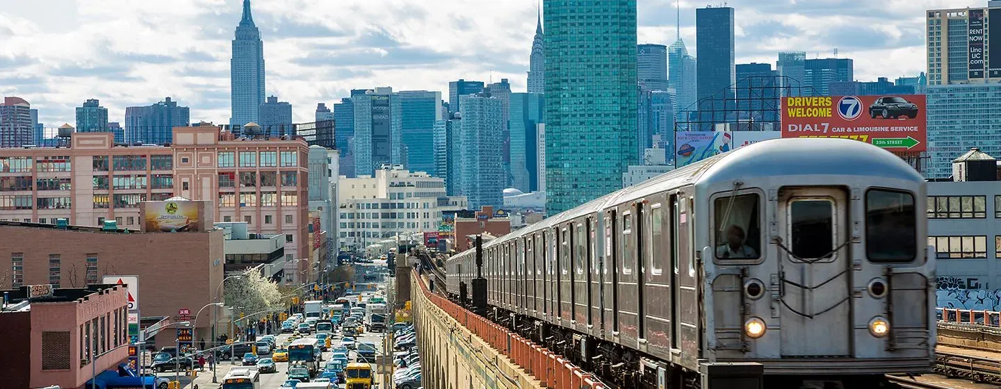 MTA New York City Transit above ground subway with a view of New York City in the background.