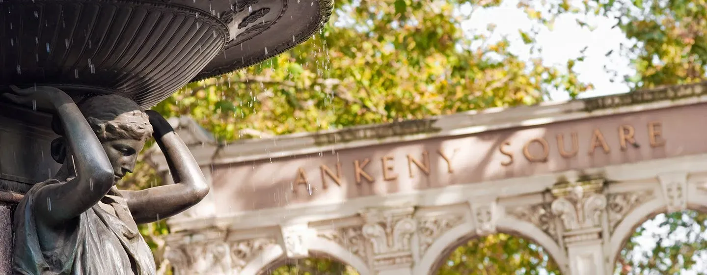 Ankeny Square, a fountain statue holds up a reservoir of water in Portland, Oregon.