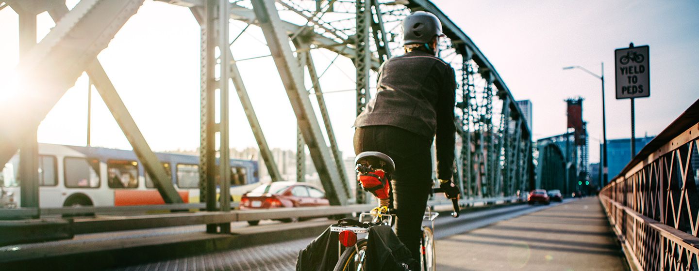 A cyclist riding a bike over Hawthorne Bridge in Portland, Oregon.