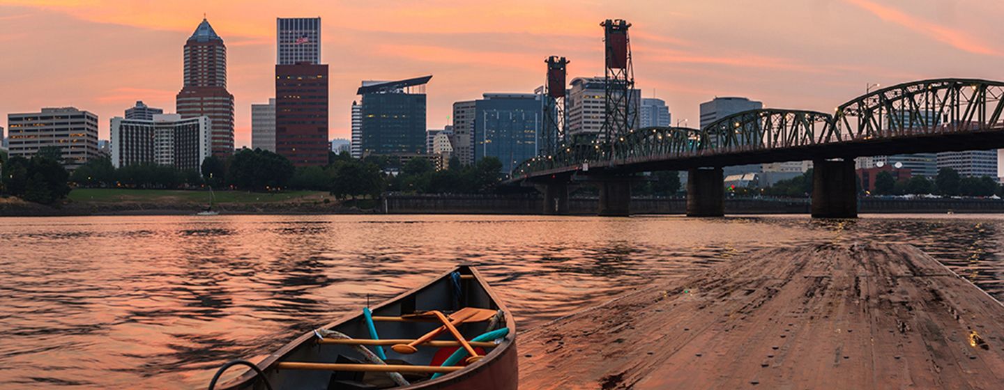 Downtown Portland, Oregon with Willamette River and kayak in the foreground.
