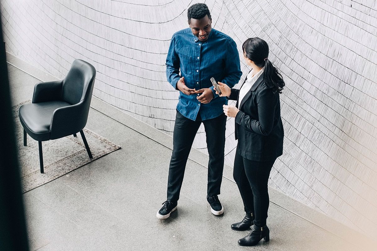 PS&D recruiter, an Asian woman in a black suit talking with a physician, a Black man, in business casual about his career.