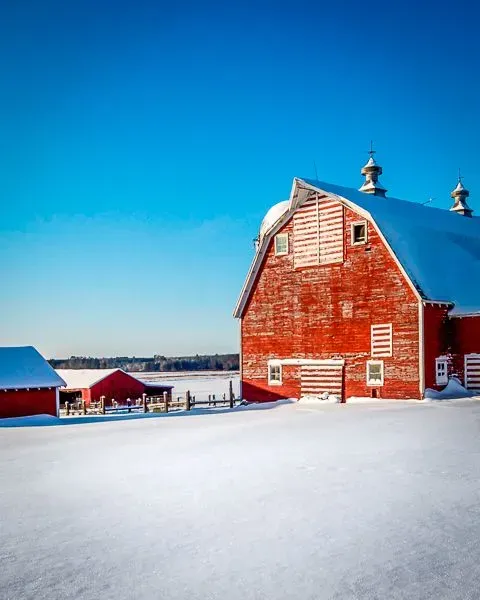 Snowy farm with red barn in Minnesota where PS&D hires physicians.