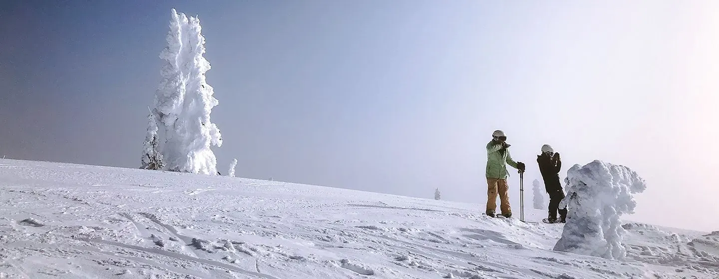 Two people skiing on a snowy slope in the state of Montana.