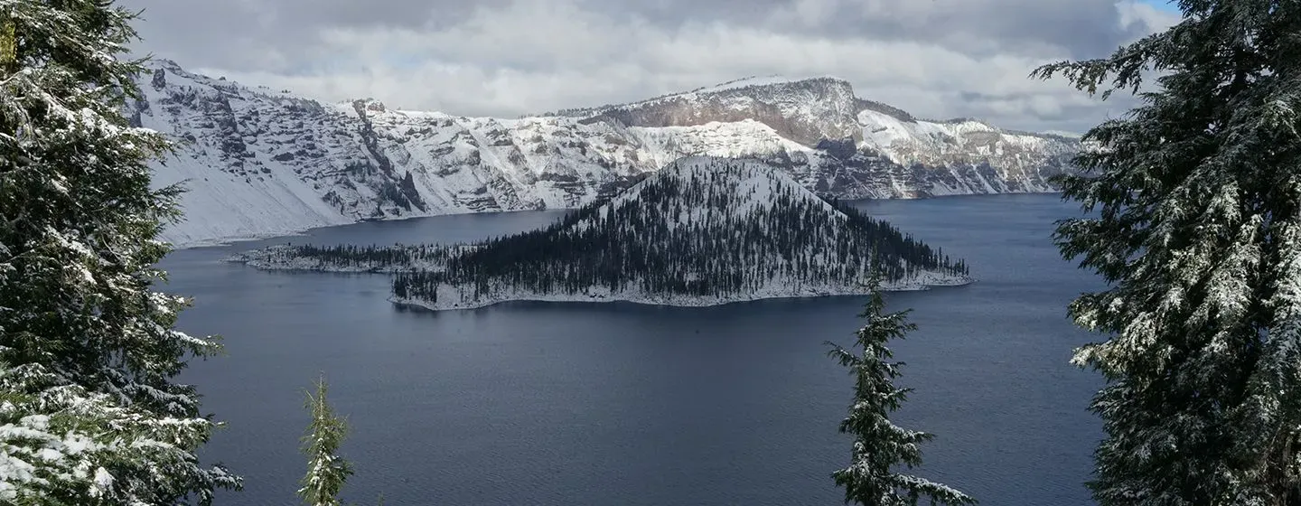 A river with snowy mountains and pine trees in Oregon.