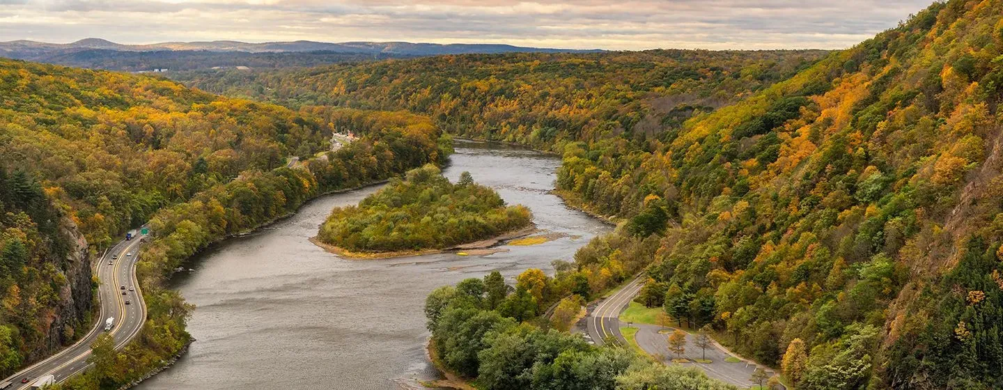 Aerial view of a river surrounded by green mountains in Pennsylvania.