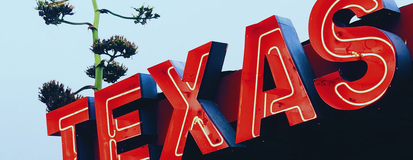 Neon red sign that says "Texas."