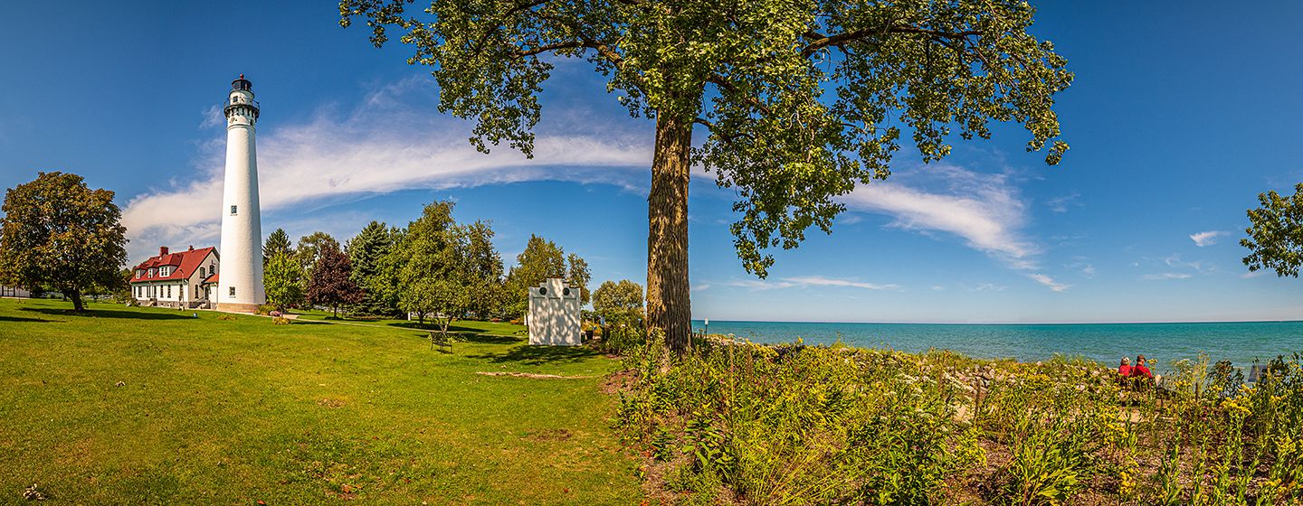 Windpoint Lighthouse in Wisconsin surrounded by a green meadow overlooking the ocean.