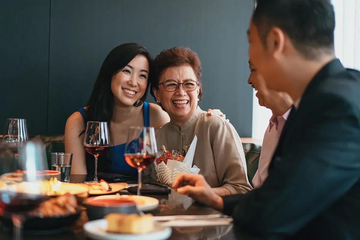 An Asian family, an older father and mother with their adult children, celebrating their son's new job in Family Medicine.